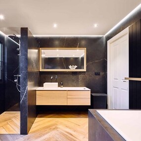 Modernes Badezimmer mit dunklen Fliesen, Holzwaschtisch, offener Dusche und Badewanne.